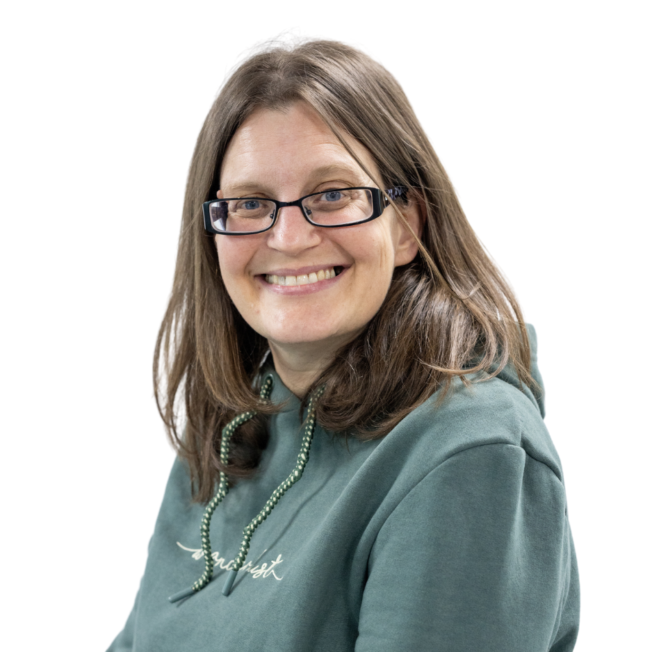 Woman smiling in green hoodie and glasses.