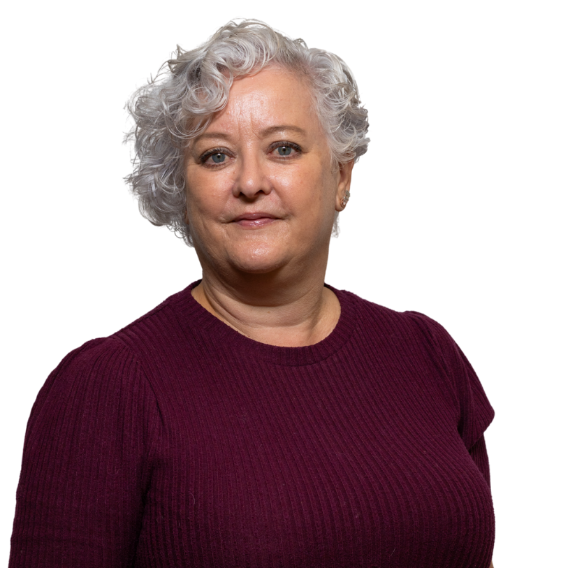 Woman with short curly grey hair, wearing maroon jumper.